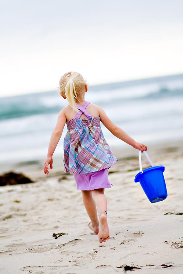 Child portraits on the beach Lily and sand bucket